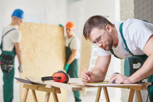construction worker drawing guide lines for timber cutting